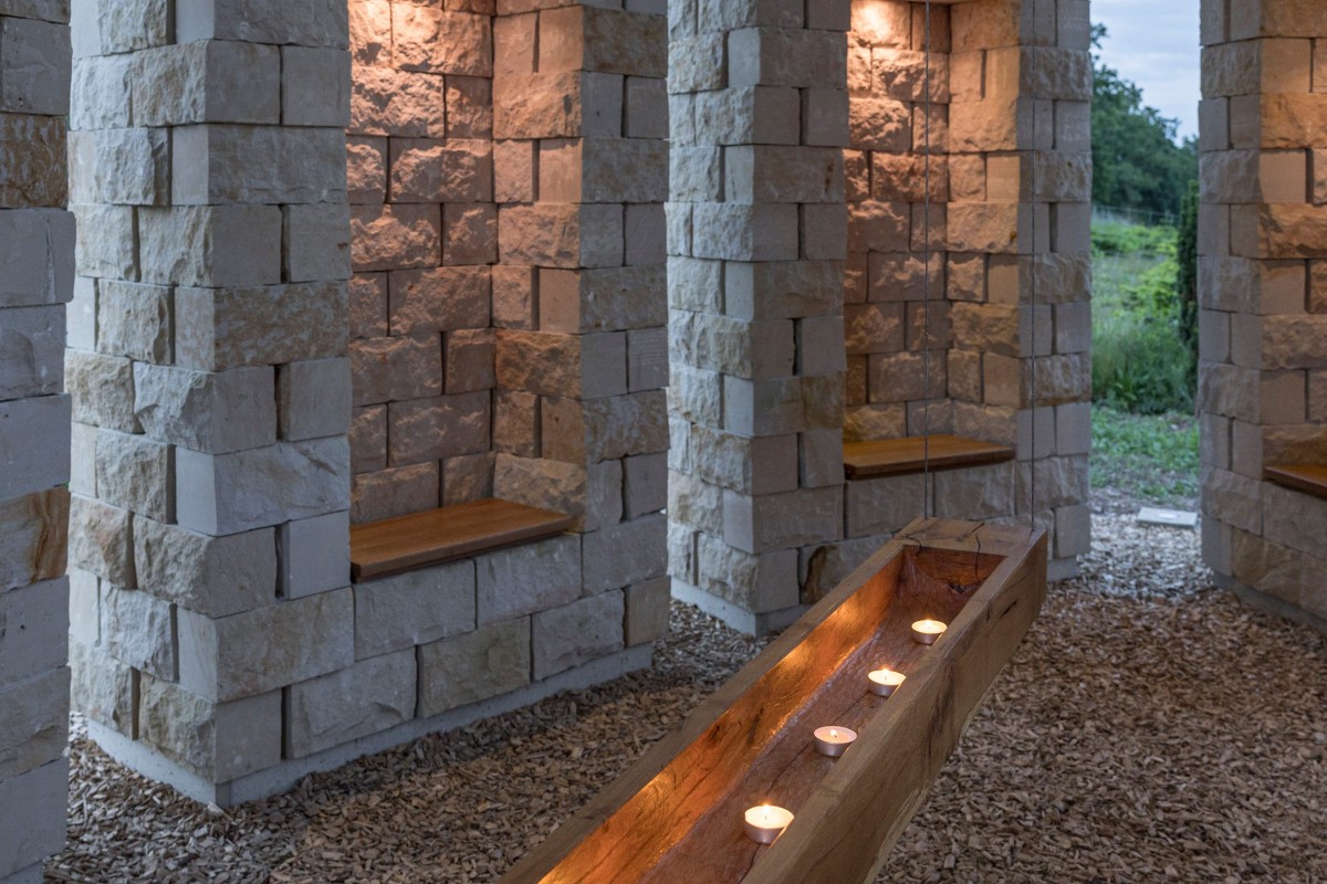 En el centro del espacio, un candelabro de madera de roble, tallado a mano por un carpintero del pueblo, cuelga suspendido de finos cables metálicos.