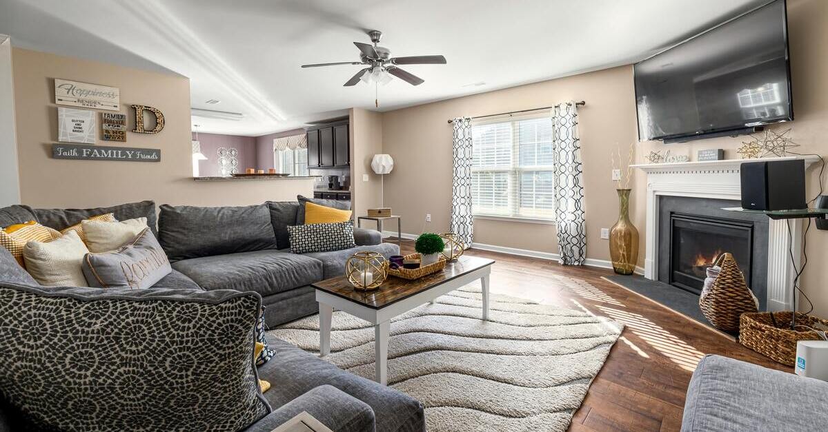 Un salotto grigio scuro con pareti color nocciola chiaro