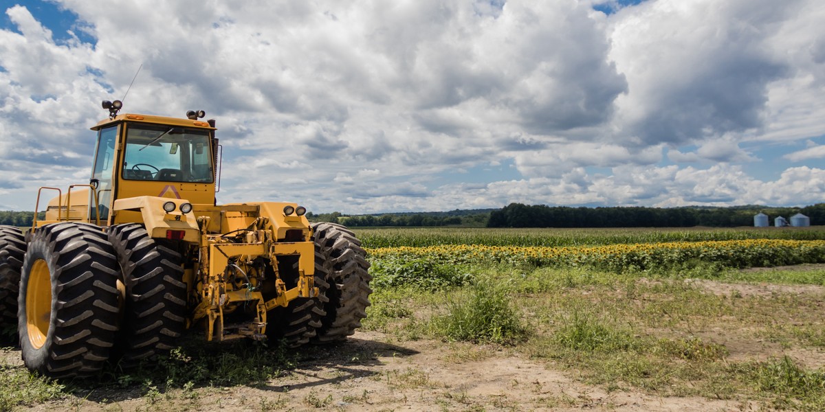 Bonus agricoltura 2025 bando Isi Inail 2024 acquisto trattori Grande trattore giallo nel girasole e campo di mais