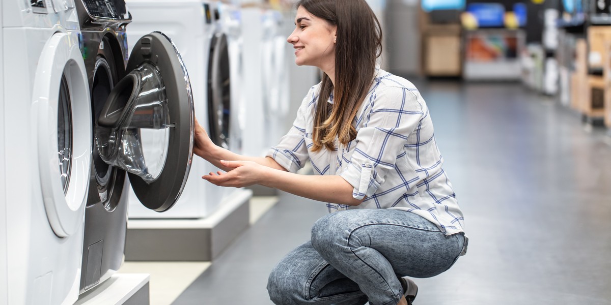 Giovane donna in un negozio di lavatrici ed elettrodomestici 