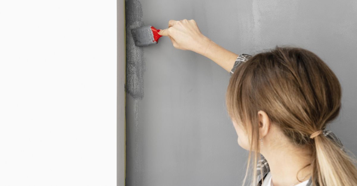 donna che dipinge parete dopo averla riparata
