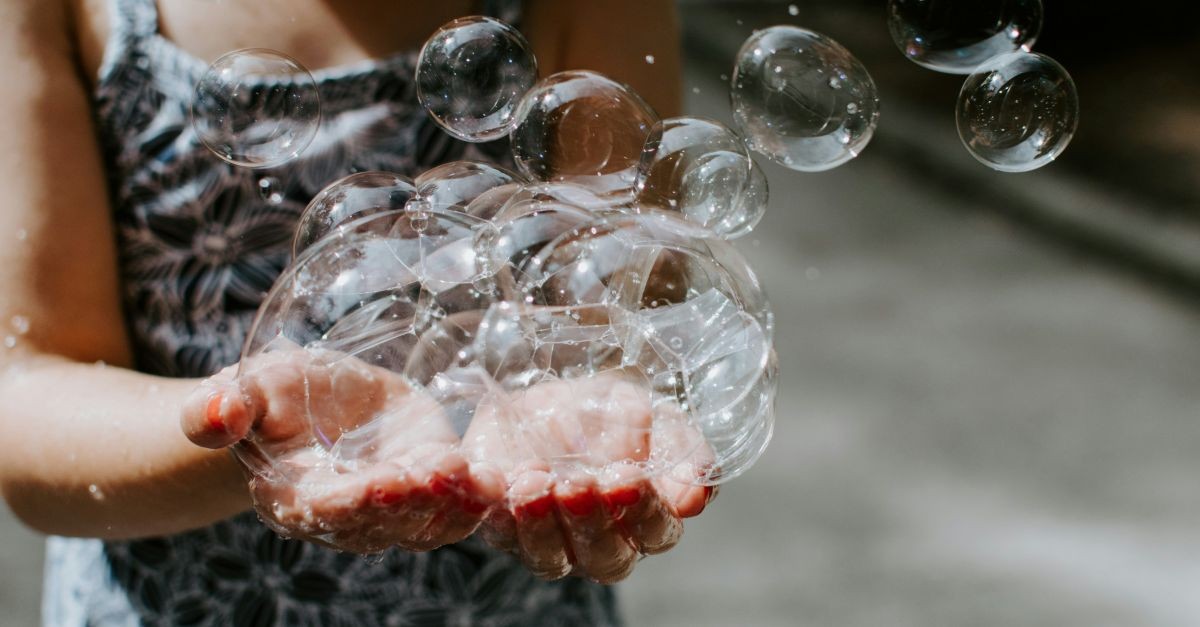 bambina che gioca con le bolle di sapone
