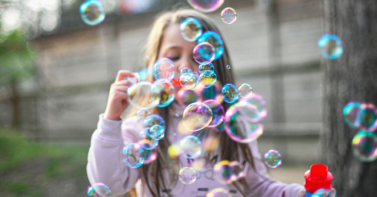 bimba che gioca con bolle di sapone