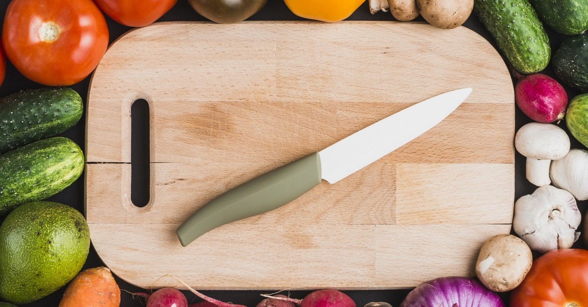 coltello in ceramica su tagliere con verdure
