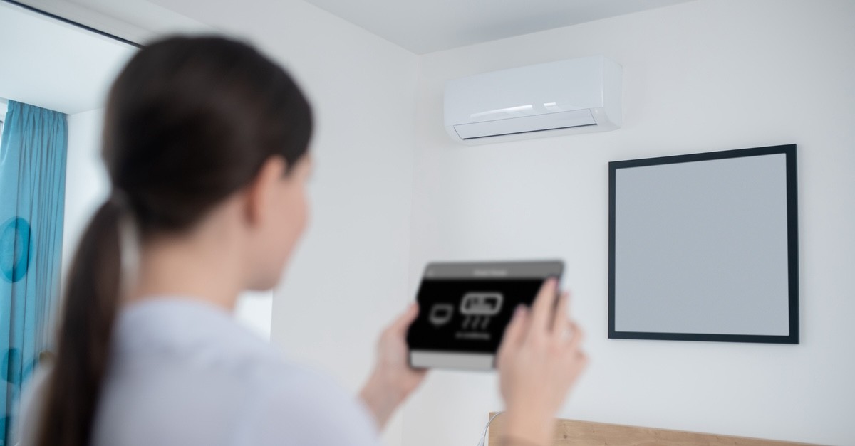 donna che accende un condizionatore senza telecomando