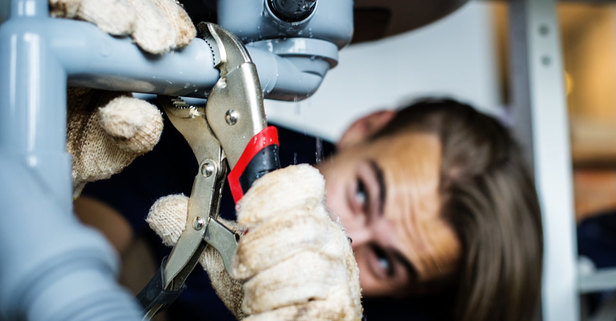 un uomo sistema una perdita d'acqua