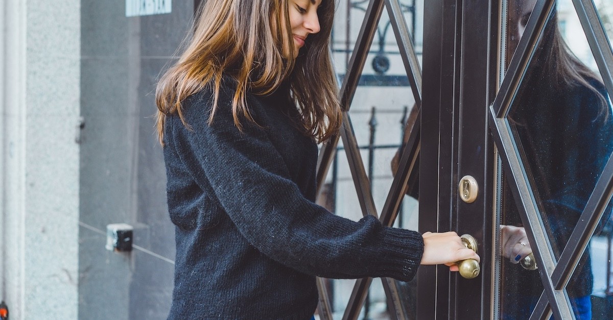 Una ragazza apre la porta d'ingresso