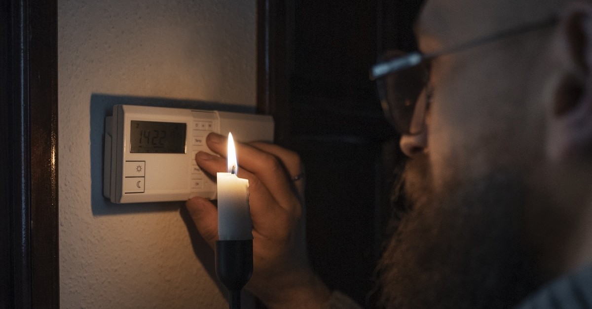 uomo che spegne il termostato al buio