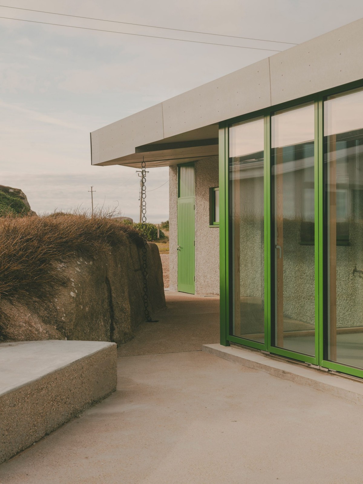 Los marcos de ventanas en verde son un guiño a la vegetación que se abre paso entre las rocas.