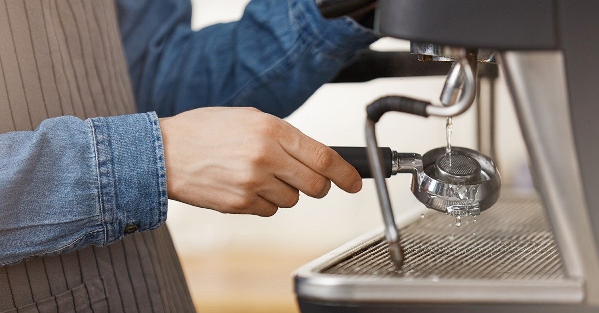 Un barista esegue la pulizia della macchina del caffè Un barista esegue la pulizia della macchina del caffè