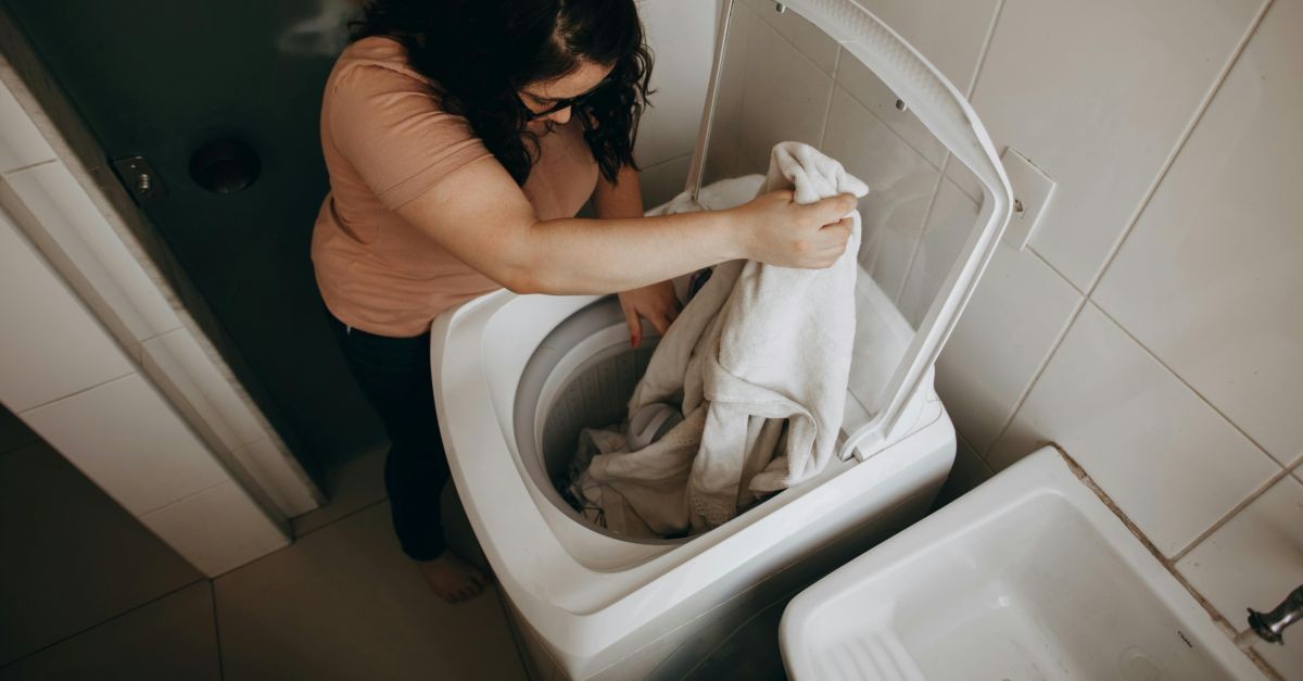 donna carica lavatrice dall'alto