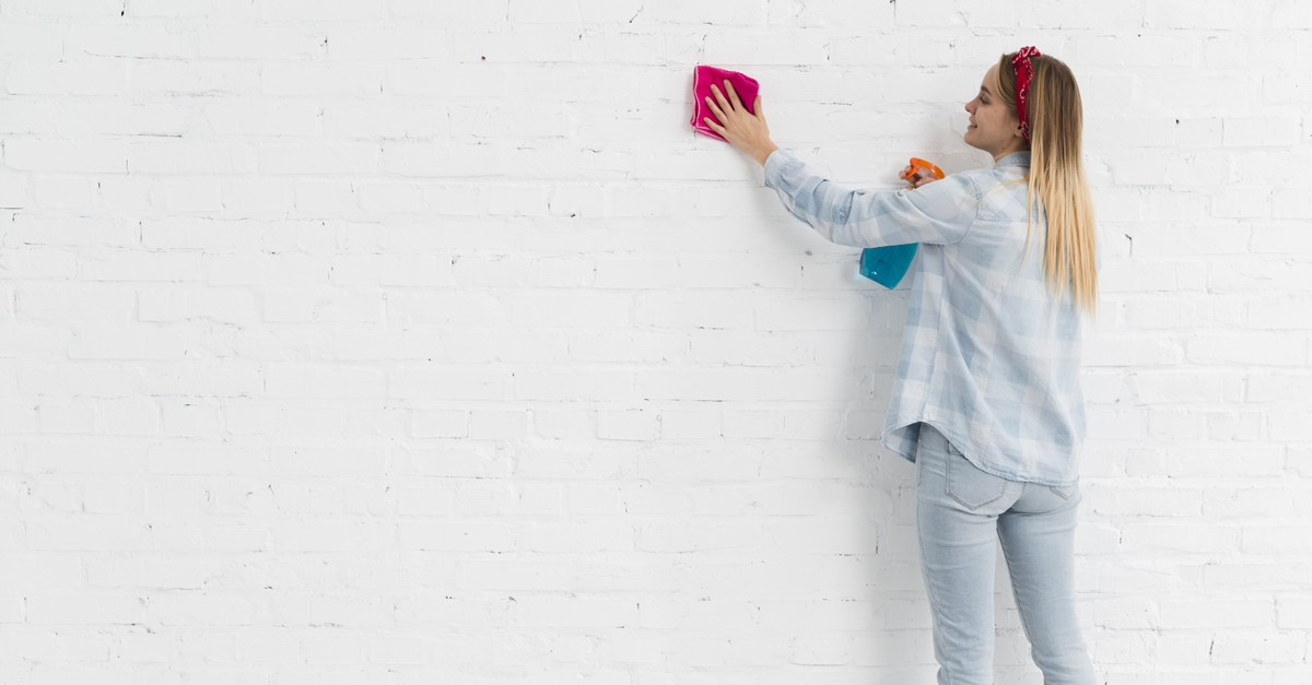 Una donna pulisce una parete