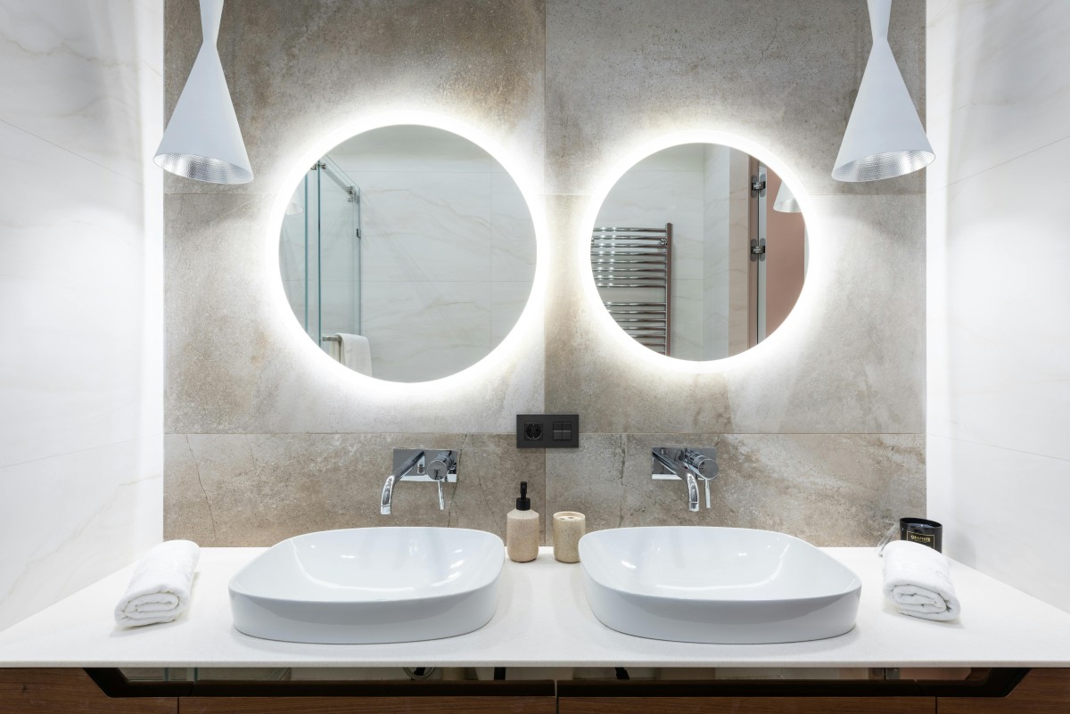Bagno con specchi retroilluminati e rubinetti con sensori