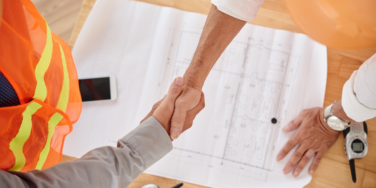 Stretta di mano con l'ingegnere per la pratica edilizia