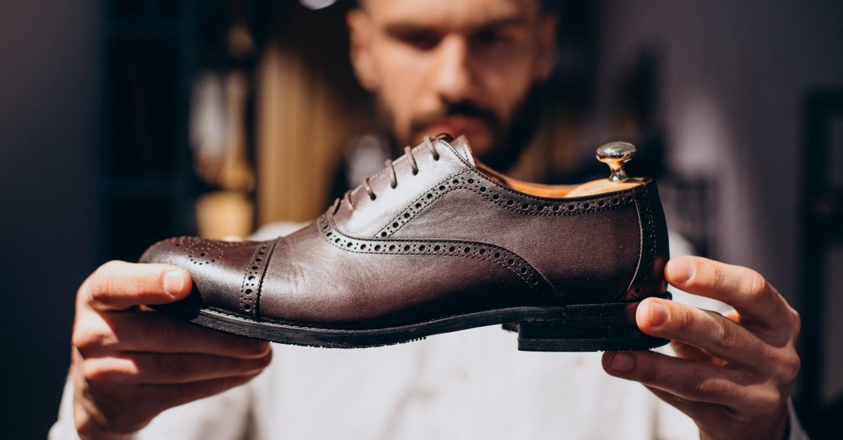 uomo che ripone scarpa di pelle