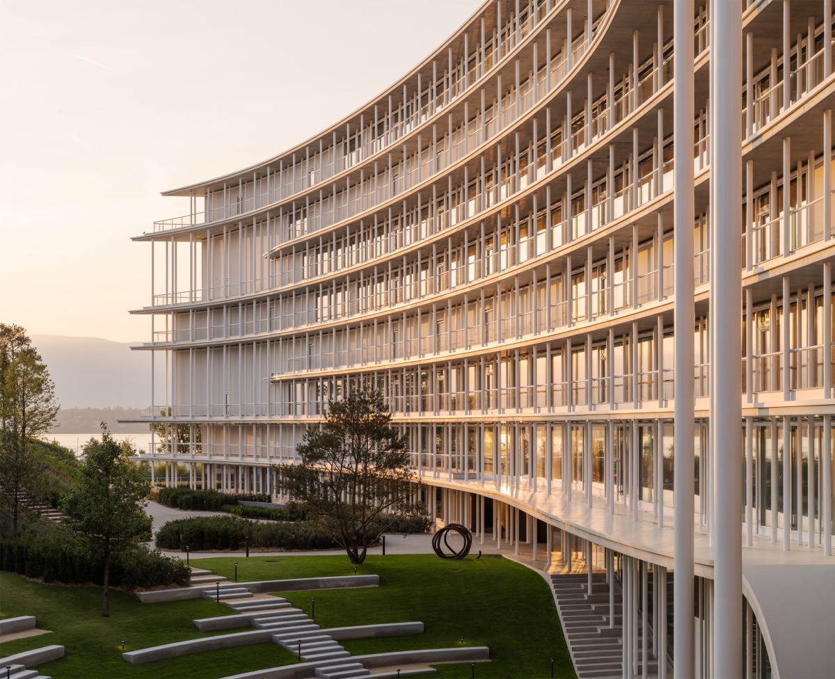 El edificio se concibió como una gran estructura exterior cuya fachada curva envuelve todos los volúmenes interiores bajo una única geometría continua.