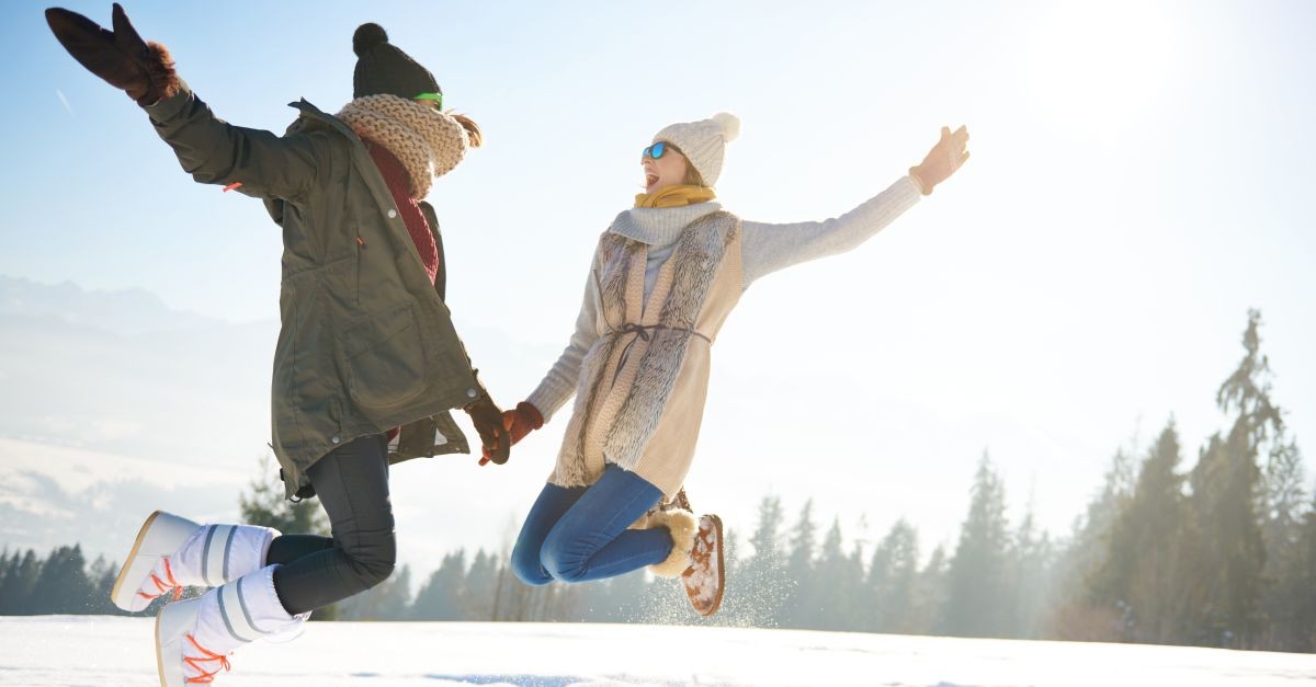 due amiche che saltano sulla neve