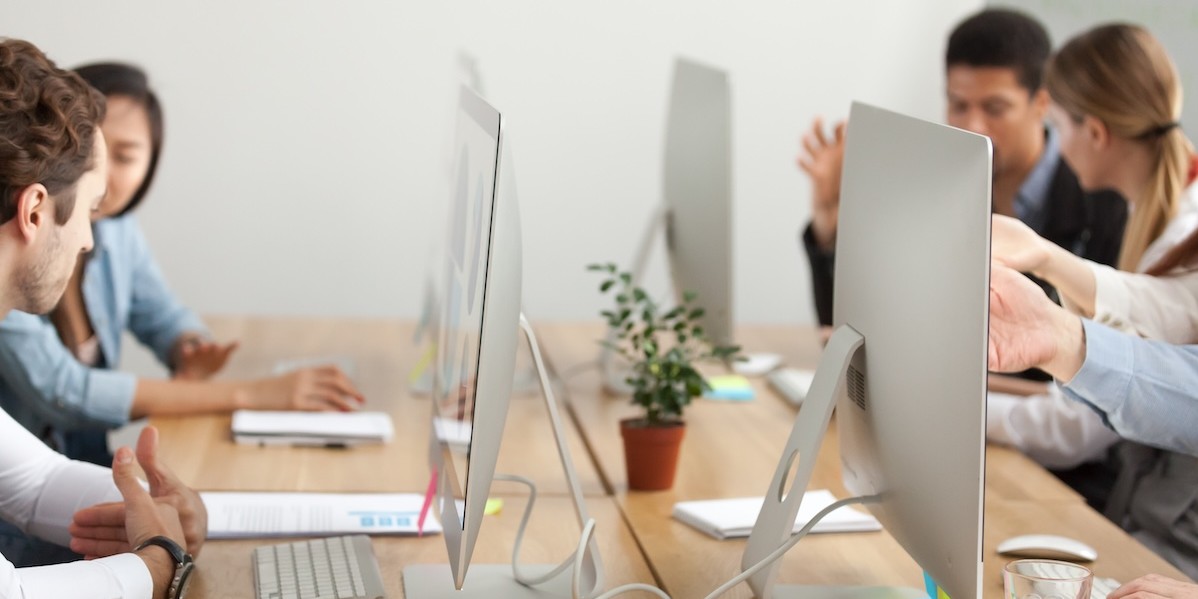 Dipendenti d'ufficio che lavorano al computer in coworking con scrivania e monitor