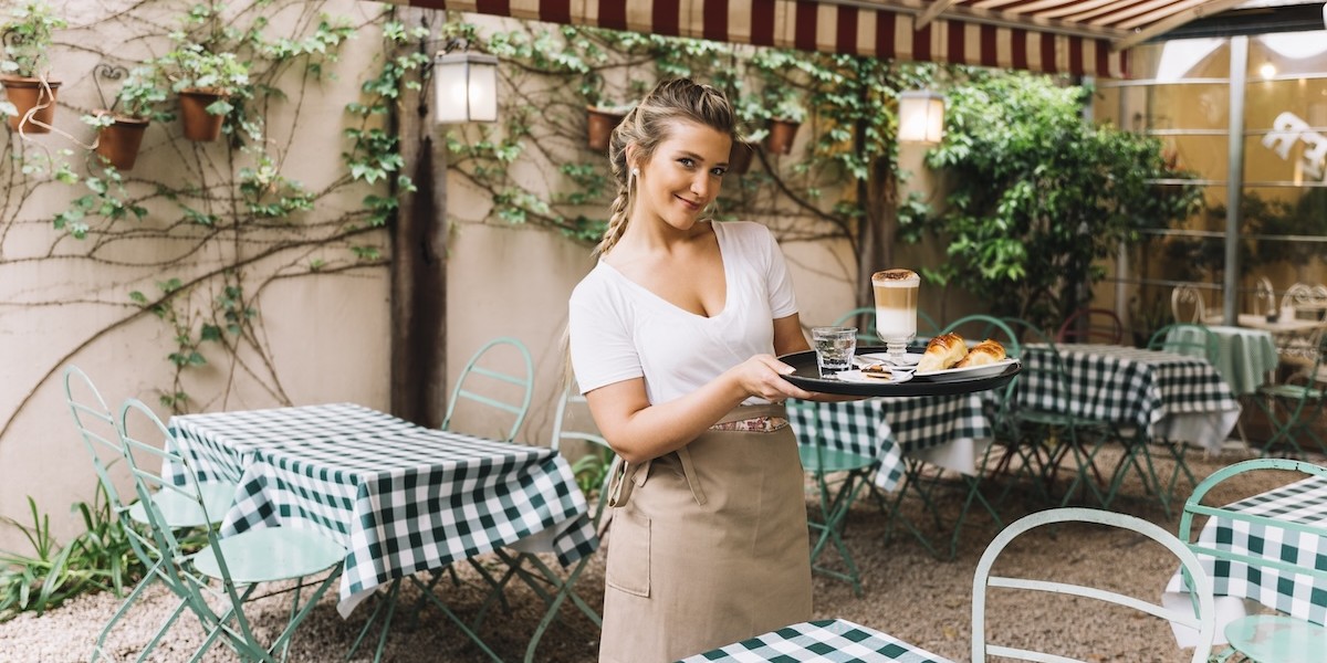 Cameriera sorridente che tiene il vassoio