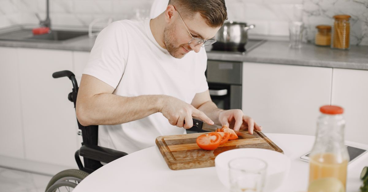 uomo su sedia a rotelle che cucina