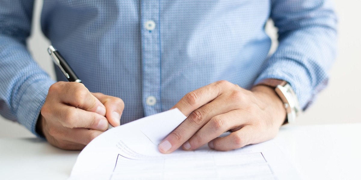 Primo piano di un uomo che firma un documento