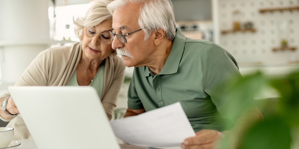 Coppia di anziani analizza i propri risparmi mentre esamina le finanze domestiche