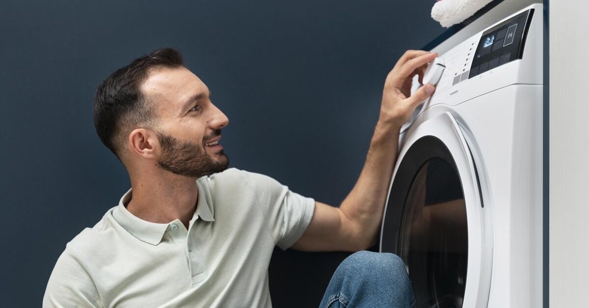 uomo che imposta il programma in lavatrice