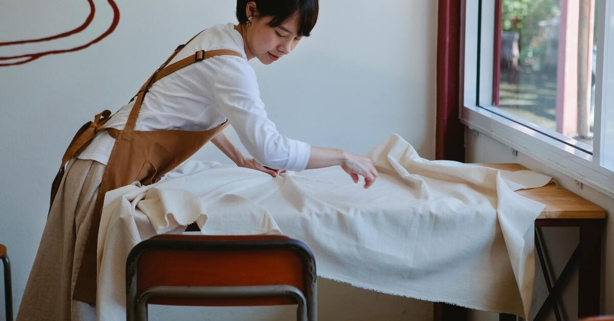 donna mette mollettone da tavolo