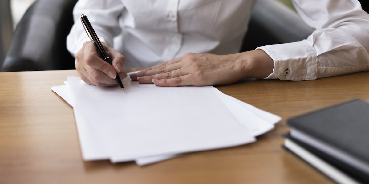 Donna concentrata a firmare un documento