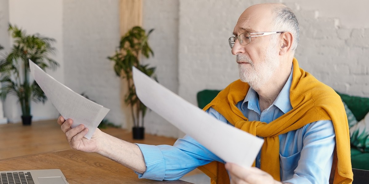 Ingegnere con computer portatile tiene documenti.jpg