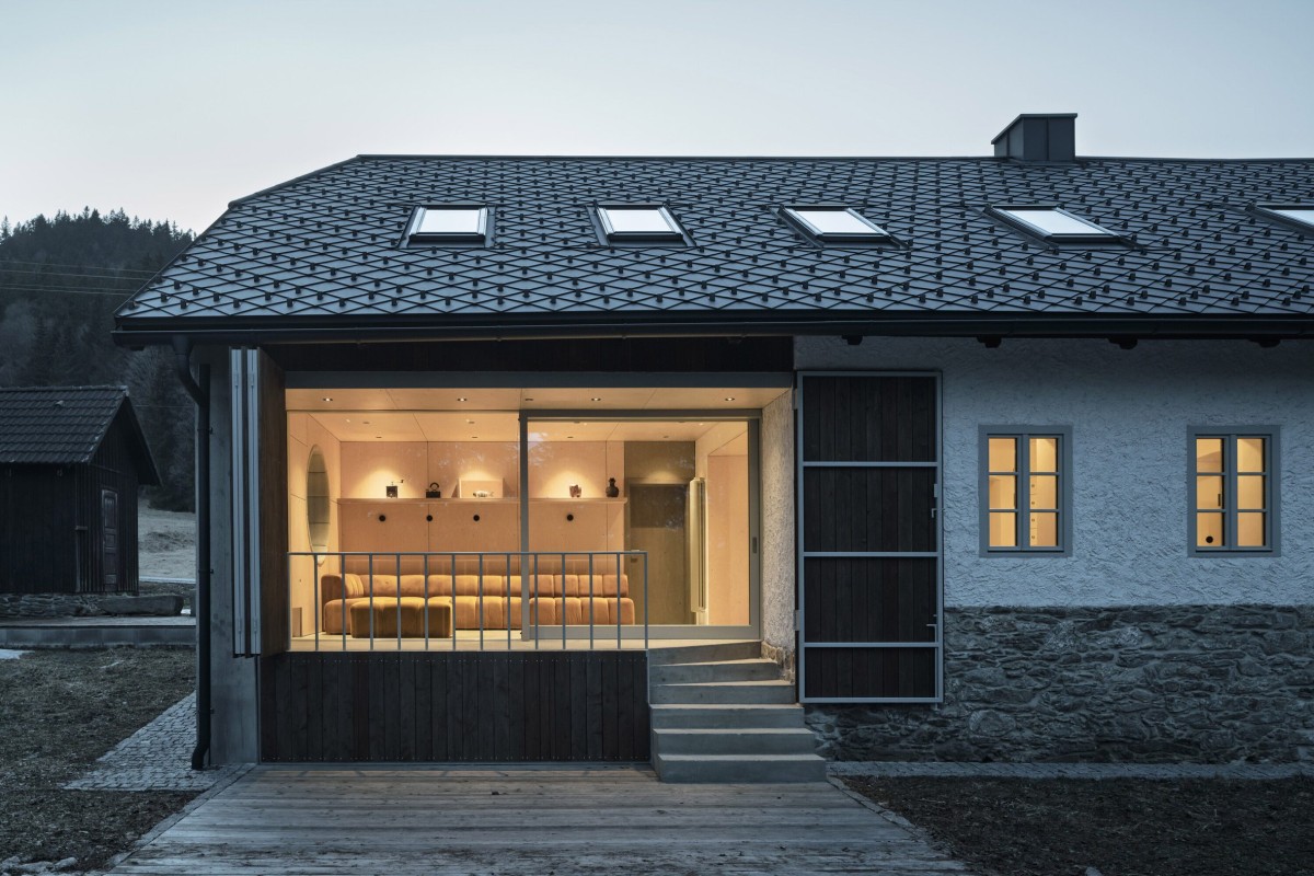 Verso l'esterno, porte scorrevoli vetrate a tutta altezza consentono di aprire lo spazio sul giardino e su una terrazza coperta