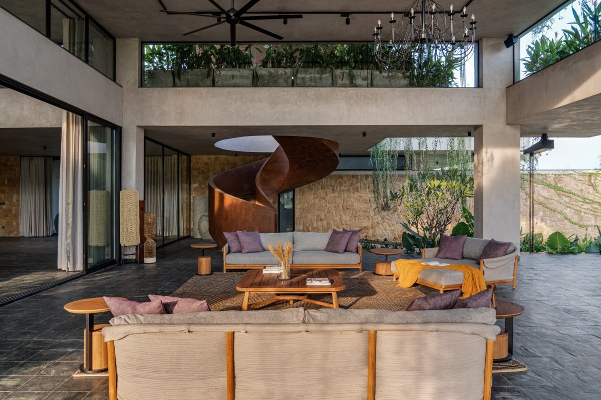 Una scala a chiocciola scultorea collega la terrazza ombreggiata a una seconda zona lounge e alla camera da letto principale