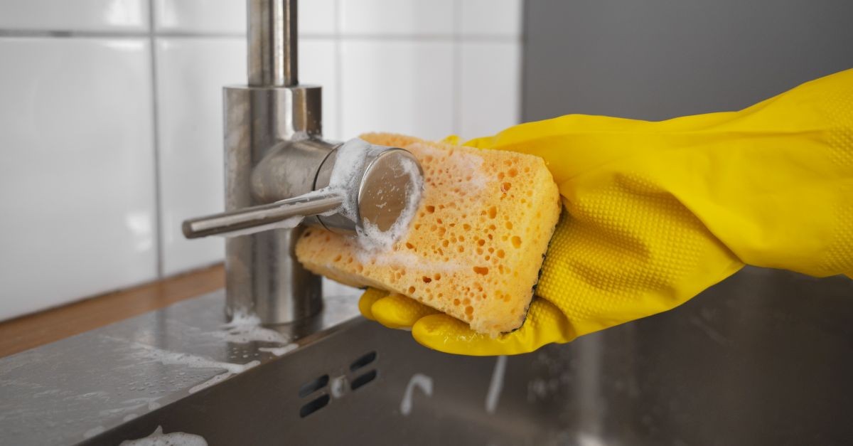 Persona che usa spugna da cucina