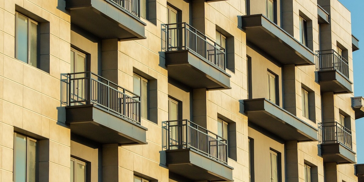 Ripresa dal basso di un condominio moderno con balconi aggettanti disposti in modo regolare