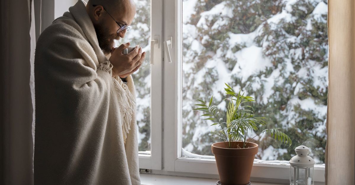 Uomo davanti a finestra in inverno
