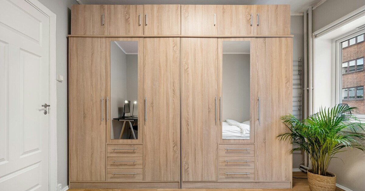 Armadio in legno chiaro con specchi e cassetti