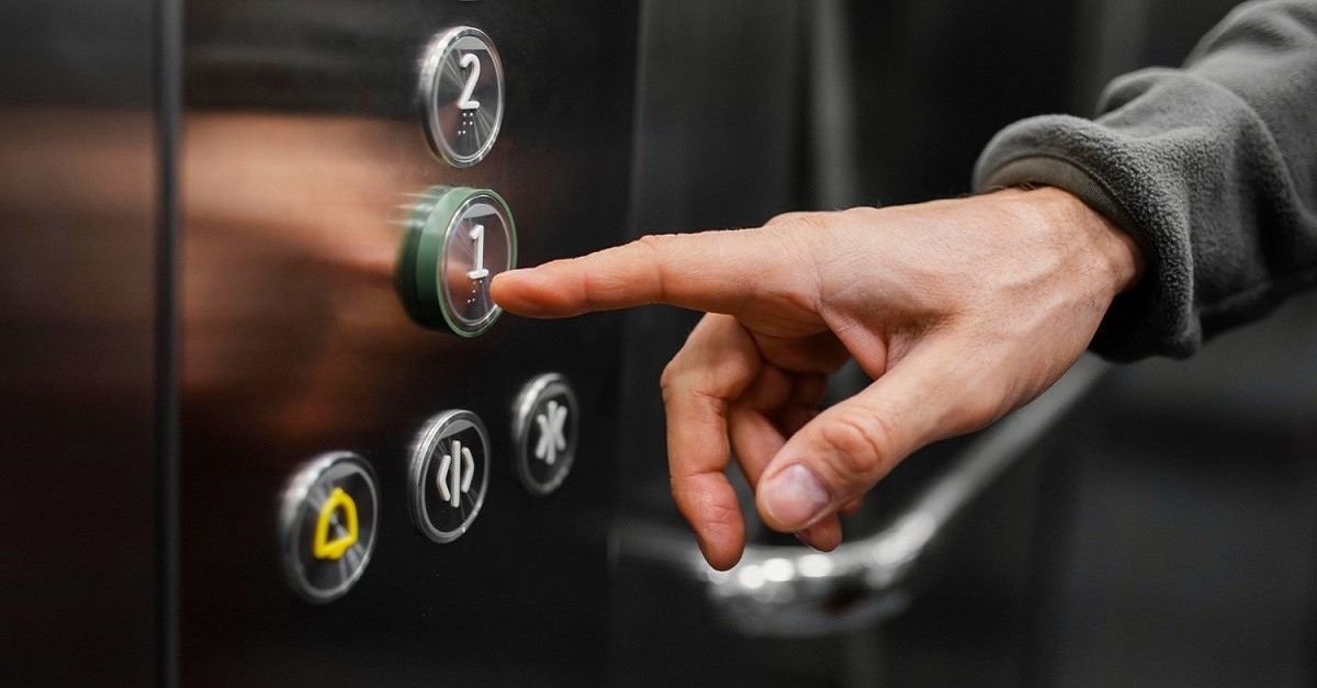 Una persona preme un pulsante in ascensore