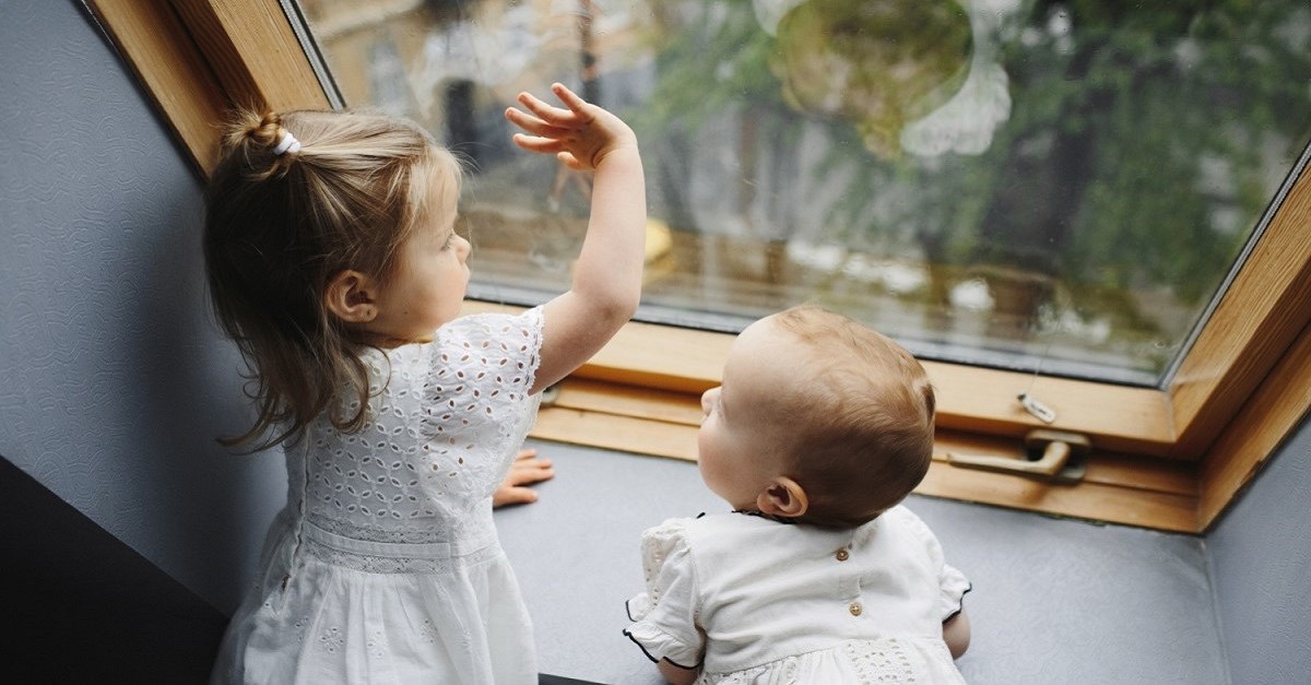 Bambini che guardano dalla finestra