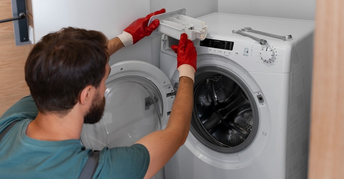 Un tecnico ripara una lavatrice