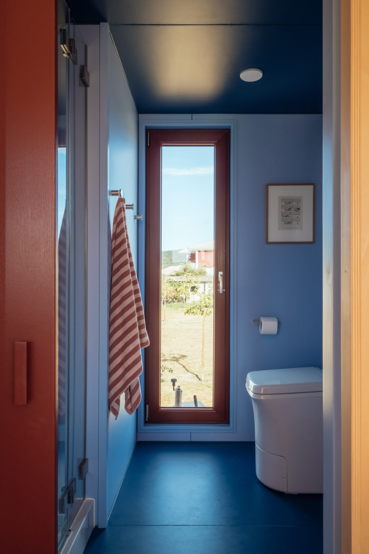 Il bagno rompe la palette neutra con finiture blu, creando un'atmosfera ultraterrena