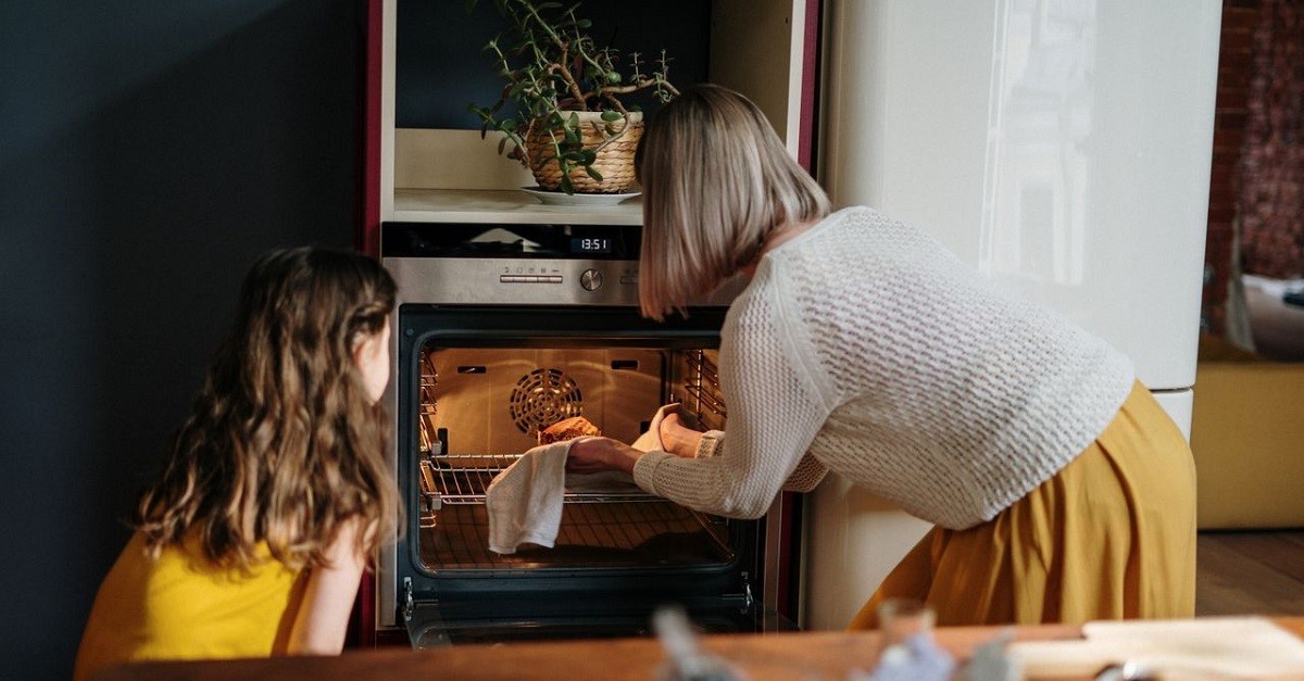 Una donna toglie una pietanza dal forno