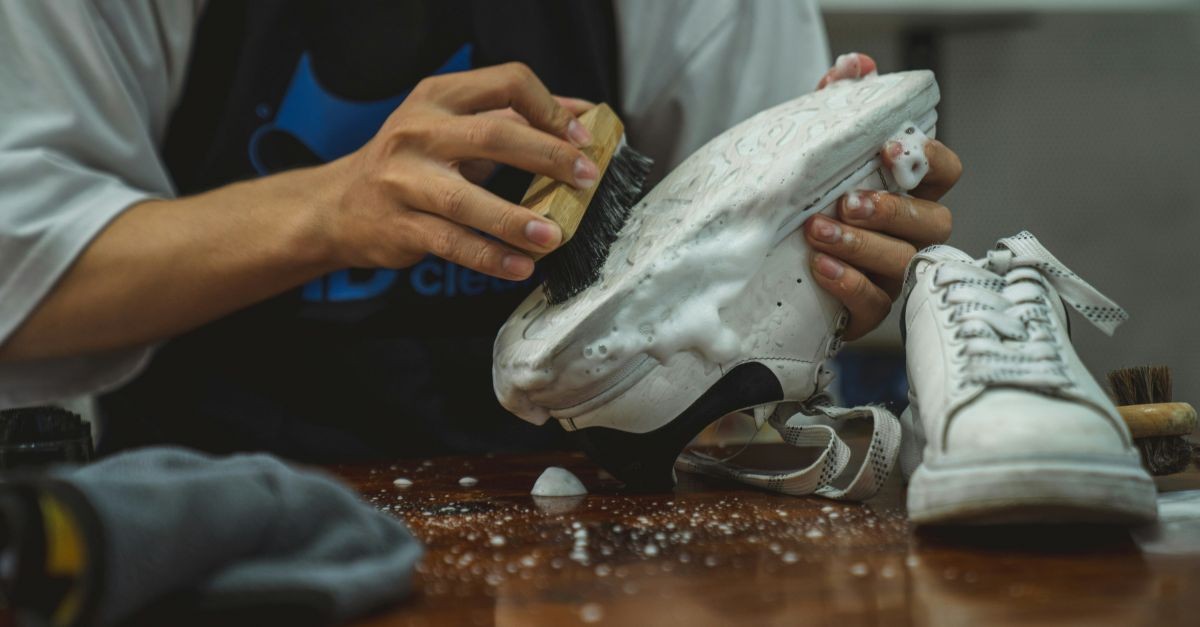 uomo che pulisce sneakers bianche 