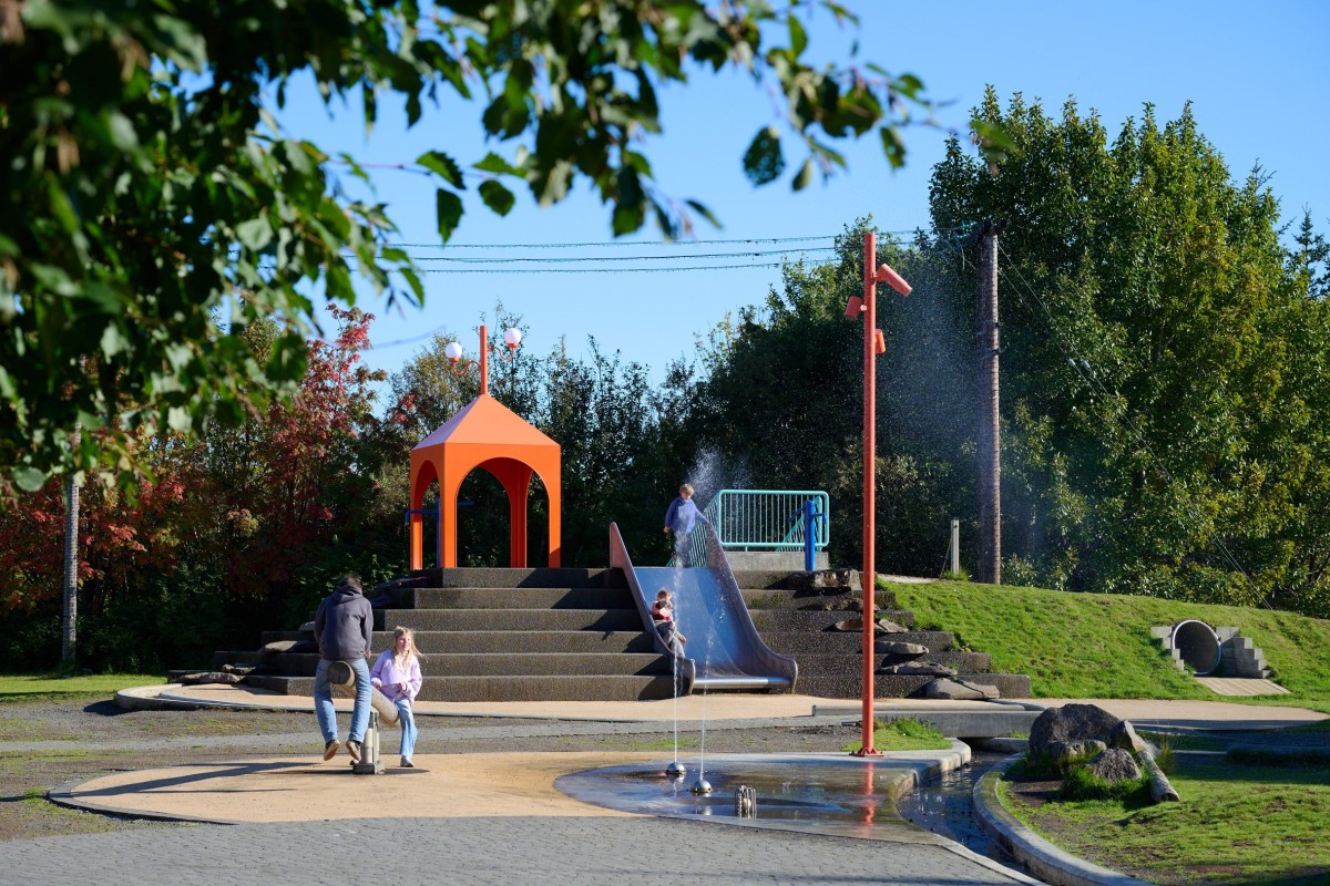 Parque acuático colorido inspirado en los principios de energía hidráulica que cuenta con un estanque para la recogida de agua de lluvia.