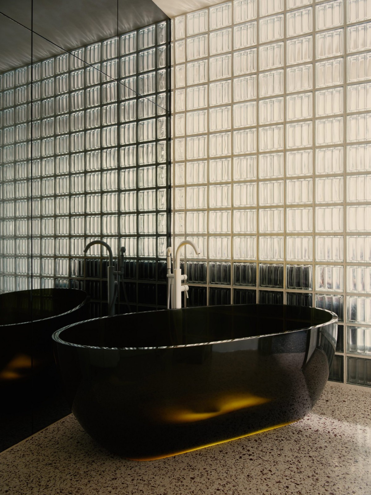 Una vasca da bagno nera e scintillante è l'elemento distintivo del bagno