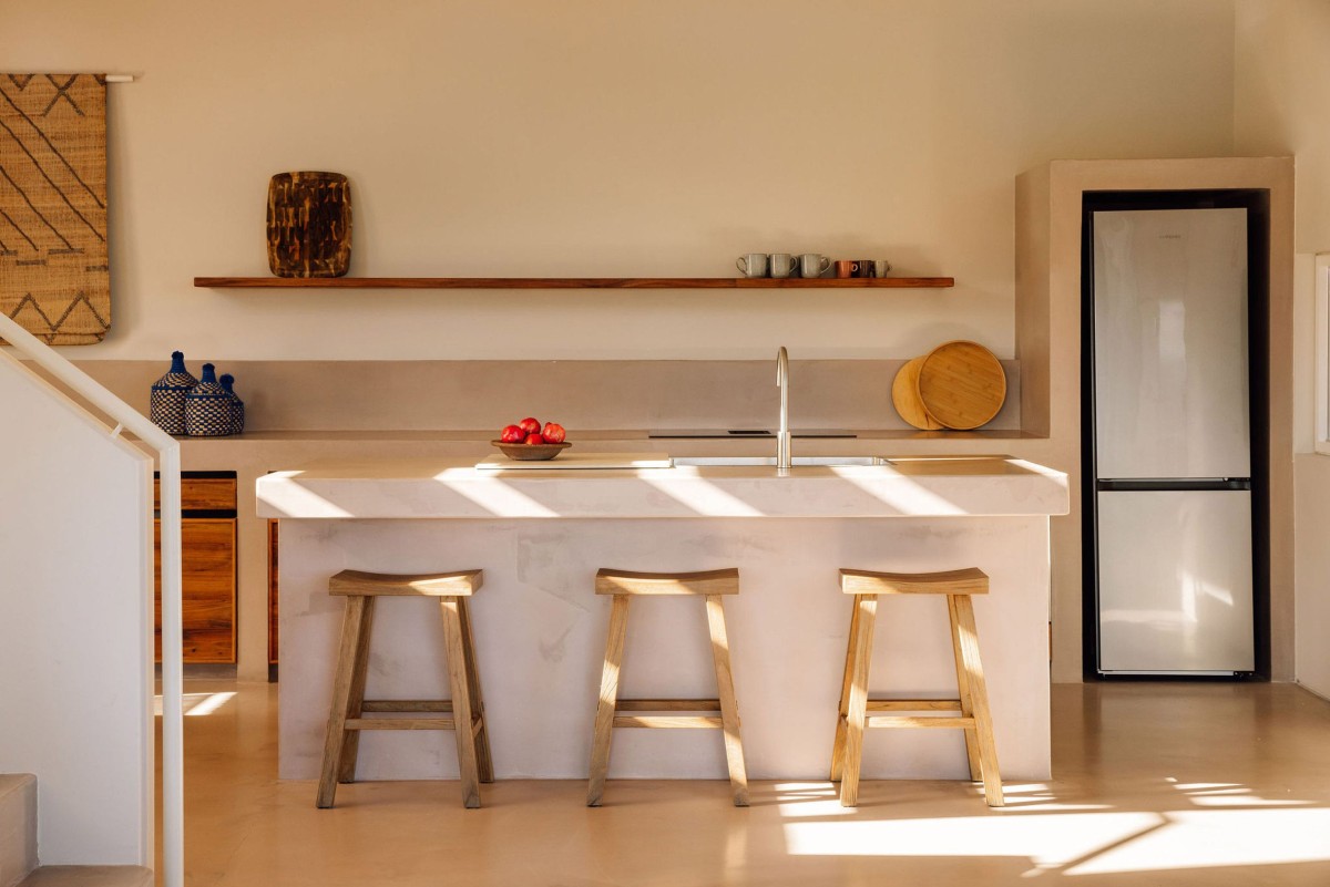 I piani di lavoro della cucina sono realizzati con lo stesso microcemento utilizzato per il pavimento e il divano a incasso
