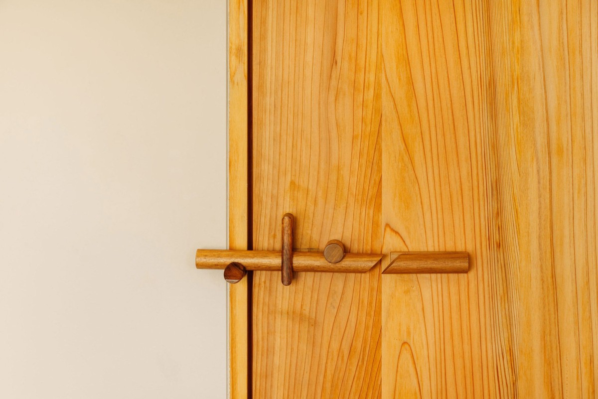 Le finiture sono completate dalle maniglie delle porte, realizzate in legno di acacia, che reinterpretano le ingegnose chiusure tradizionali