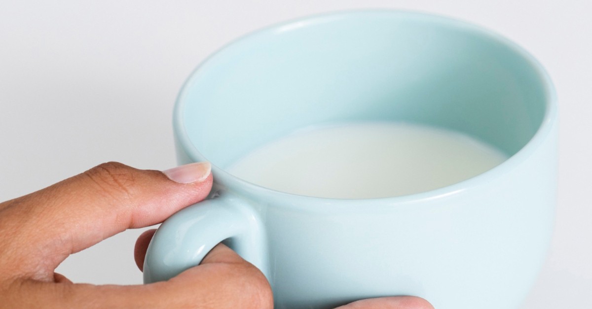 Una tazza celeste con latte dentro