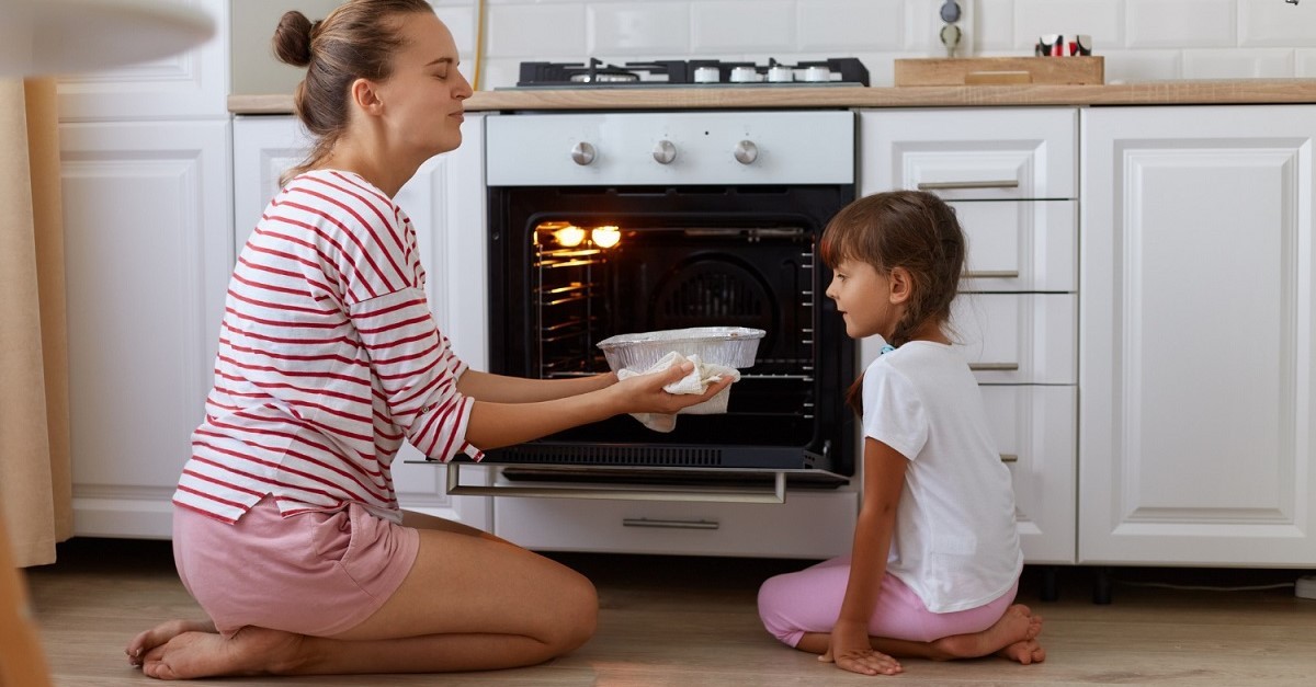 Una donna sforna un dolce davanti a una bambina