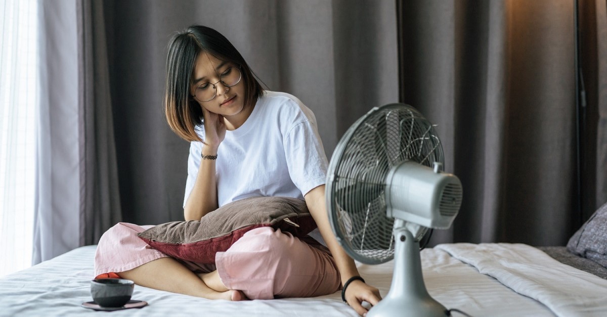 Ragazza sul letto con un ventilatore
