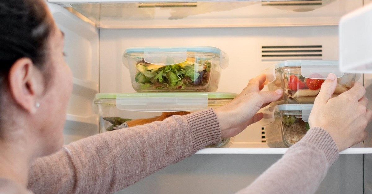 Donna prende un contenitore dal frigo
